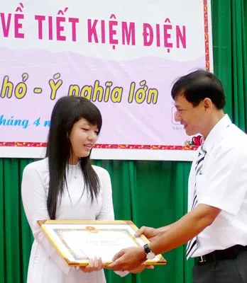 Em Võ Thị Quỳnh Hương (trái), học sinh lớp 12A2 Trường THPT Hàn Thuyên, nhận giấy khen của EVN HCMC.